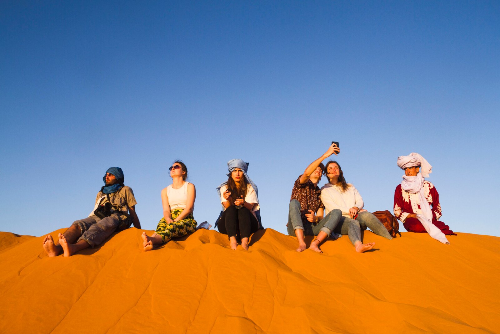 group-people-sitting-top-dune